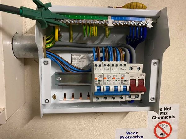 Metal consumer unit with RCBO protection undergoing live electrical verification