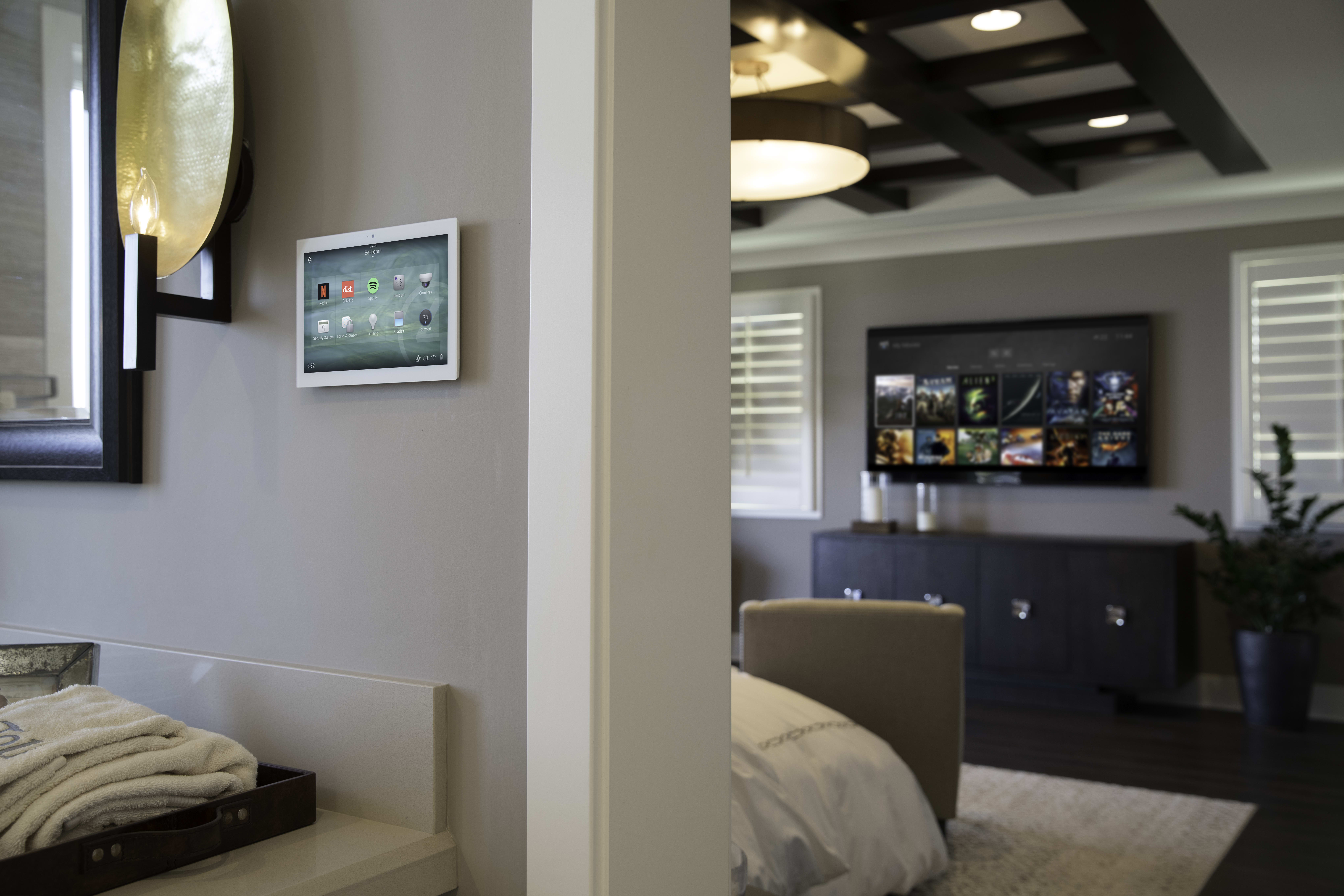Luxury bedroom with in-wall smart-home touch panel and integrated television system
