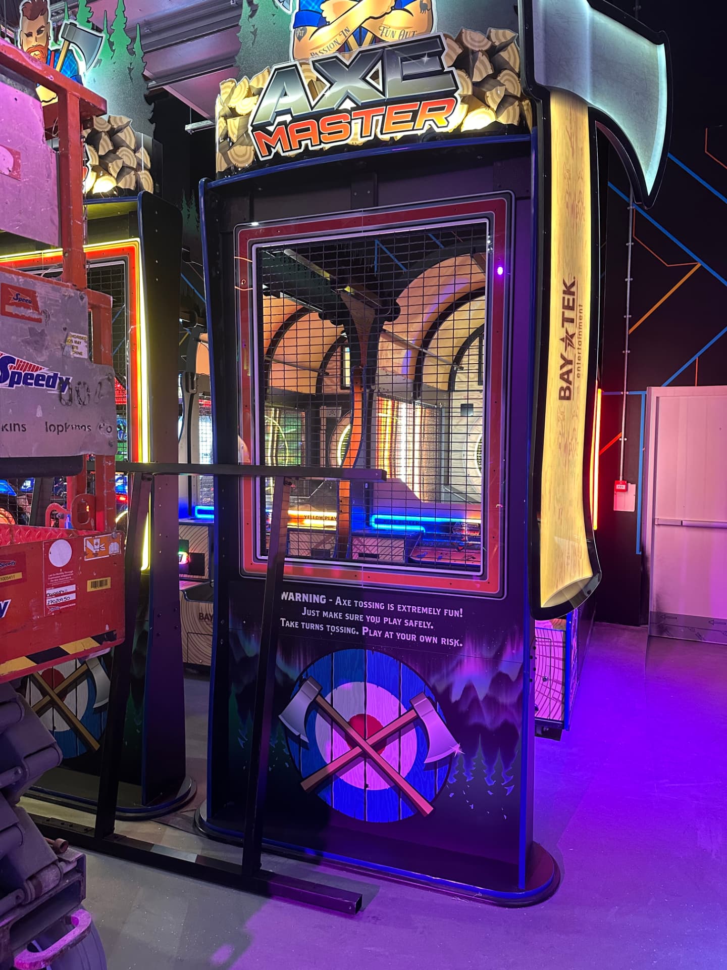 Axe throwing arcade cabinet installed in a themed venue bay