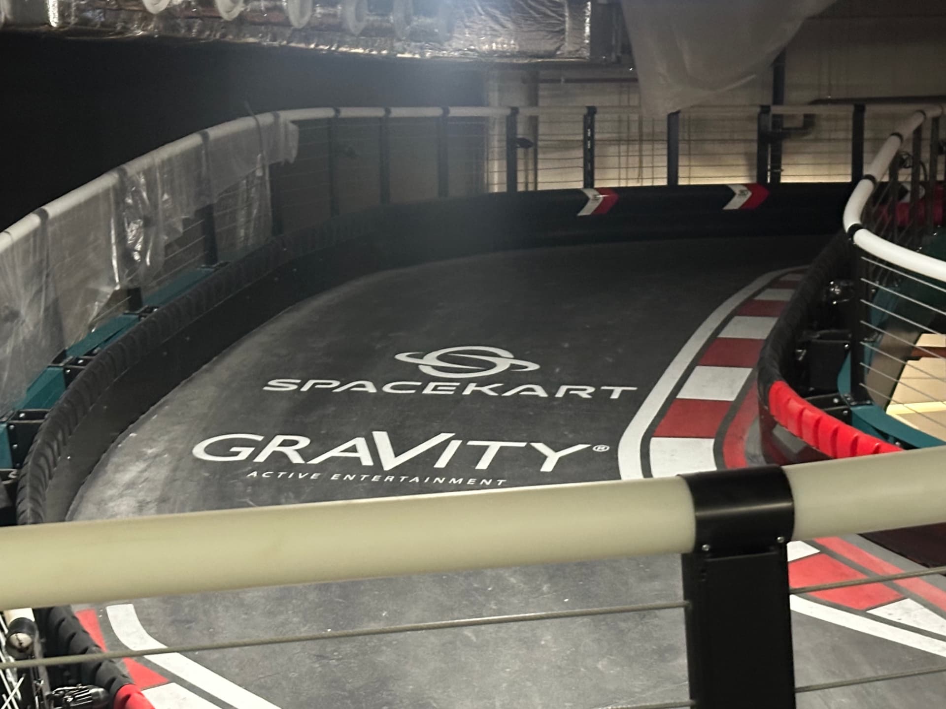 Indoor electric karting track surface with barriers and low level lighting