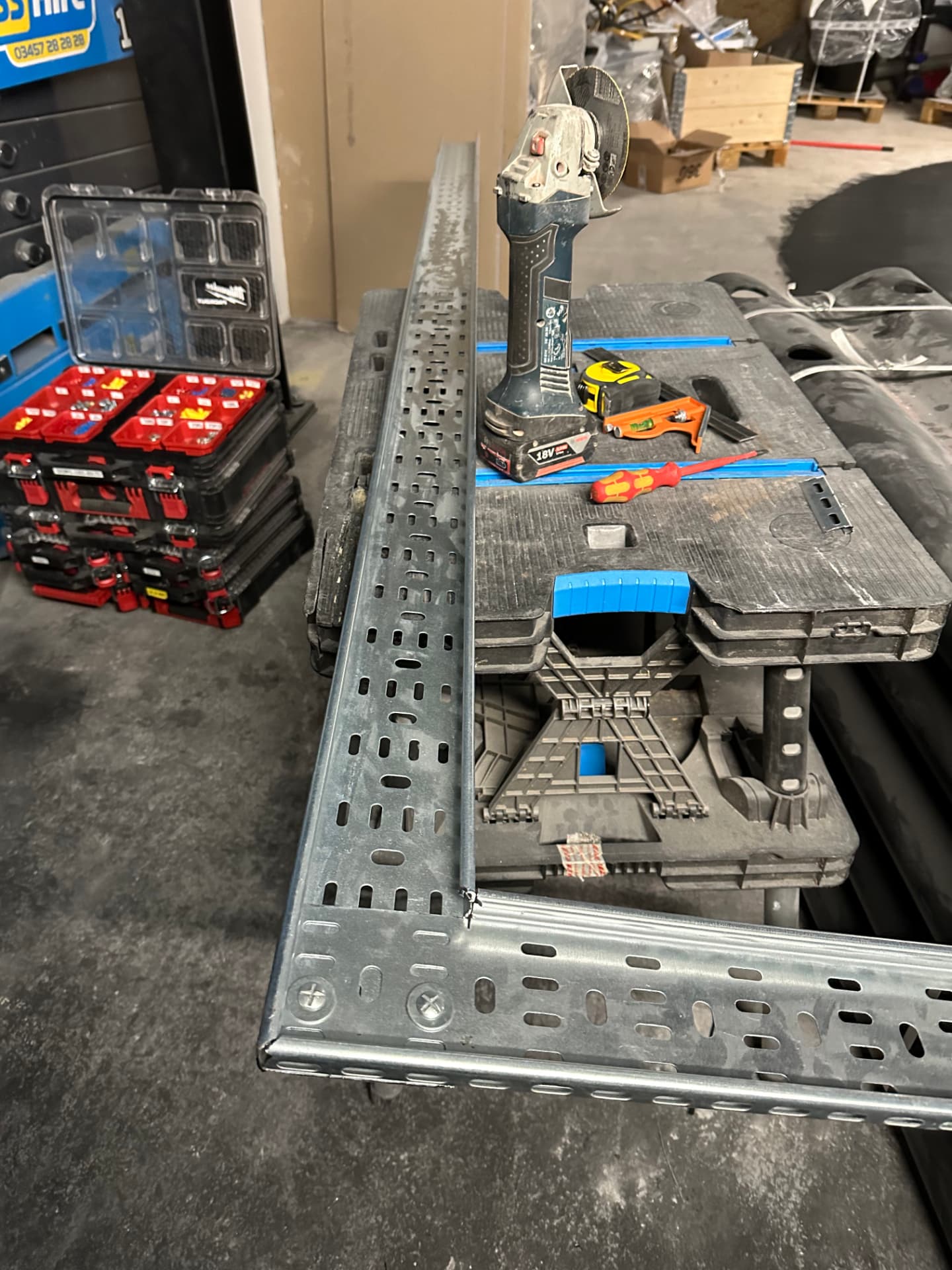 Cable tray being cut to length with an angle grinder on site