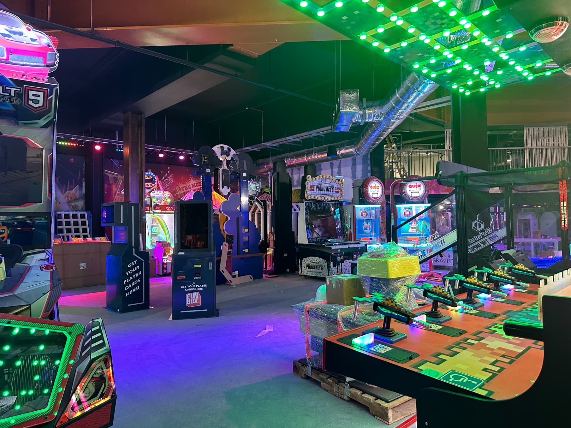 Arcade zone with a green LED ceiling feature and interactive gaming installations